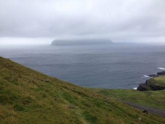 Mykines, on the other hand, the island that can be partially seen enveloped by fog in the picture, might be an objectively remote location on the globe --- it can only be reached by helicopter or boat, and under exceptionally good weather conditions --- the weather in the Faroe Islands changes often, dramatically, and rather unpredictably! (August '16)